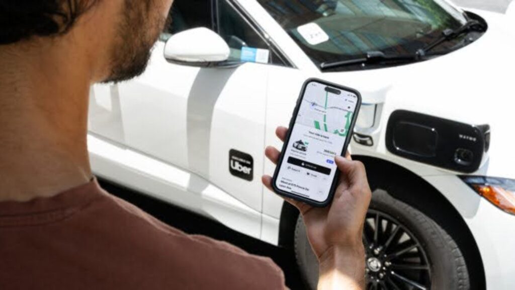 A male passenger in Atlanta booking a Waymo with the Uber app.