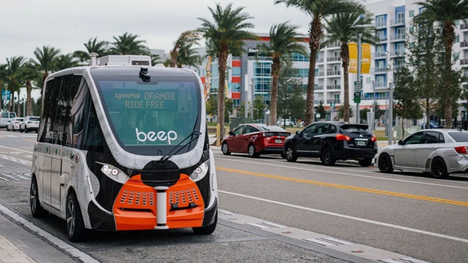A Beep autonomous shuttle vehicle driving on a Lake Nona city street.