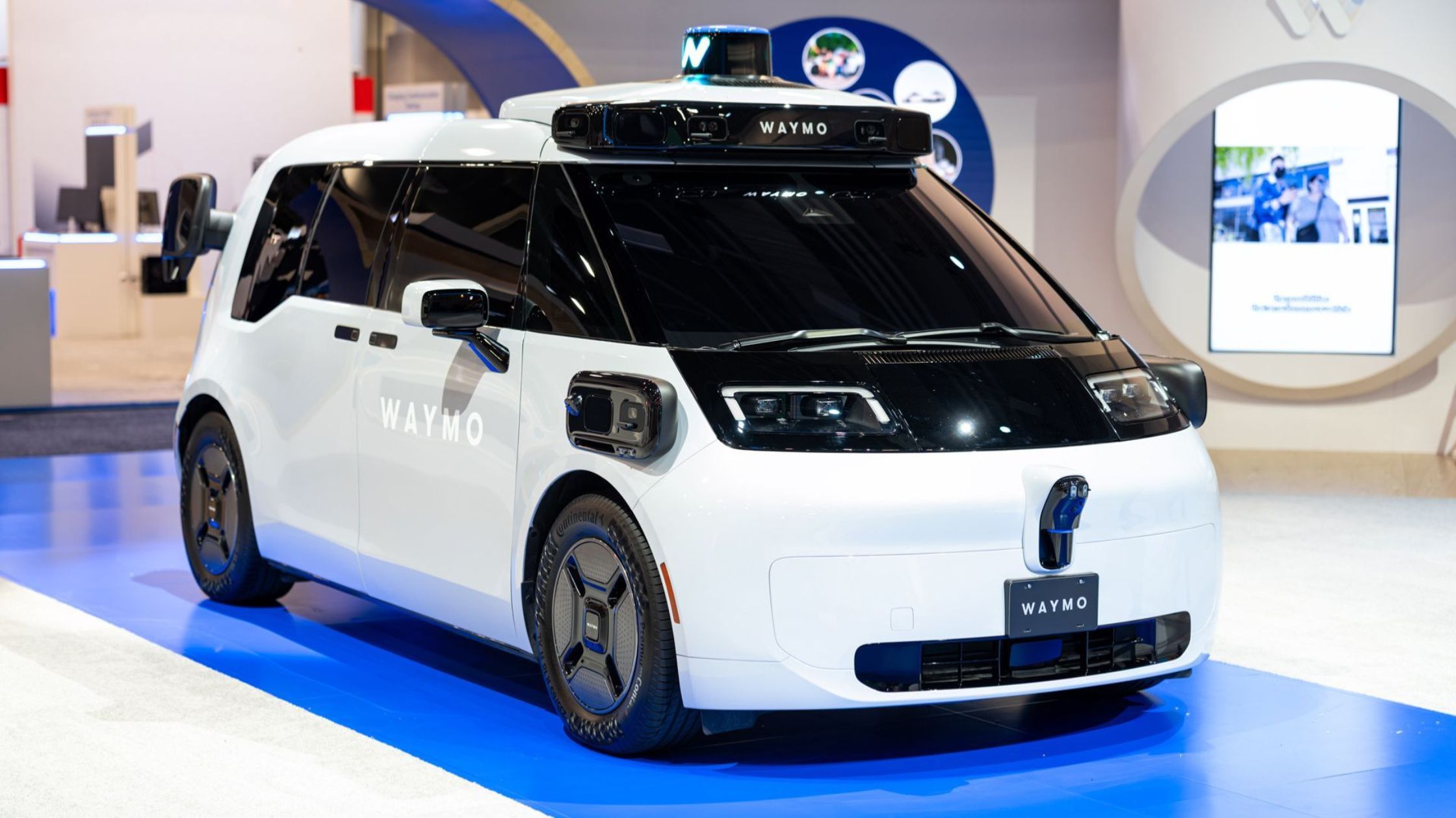 Waymo's 6th-generation robotaxi, Ojai, parked in a Waymo booth at CES 2026.