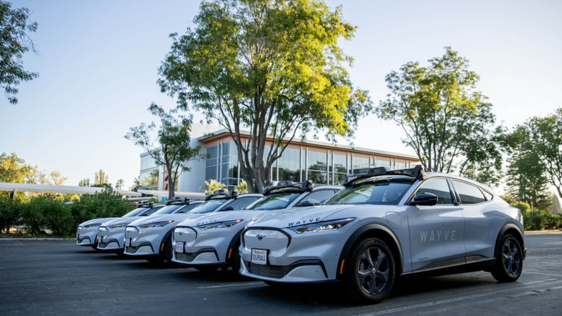 A fleet of Wayve robotaxis parked outside Wayve's facility.