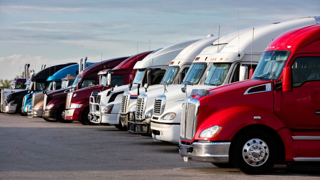 A line-up of autonomous trucks in a paking lot.