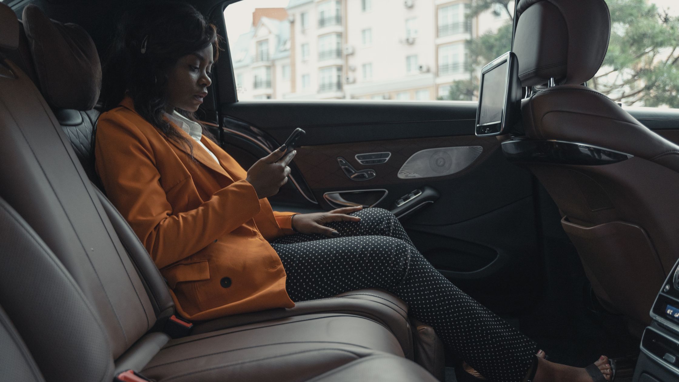 A Black woman sitting inside a Waymo robotaxi