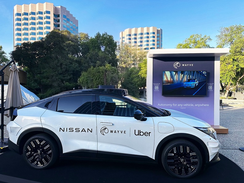 The Nissan Leaf with the Nissan, Wayve, and Uber logos sported by its side.