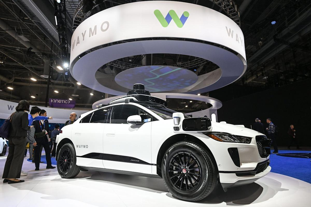 A Waymo robotaxi parked in an exhibition booth