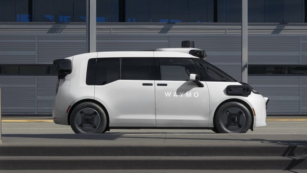 A Waymo silver robotaxi driving autonomously on the road