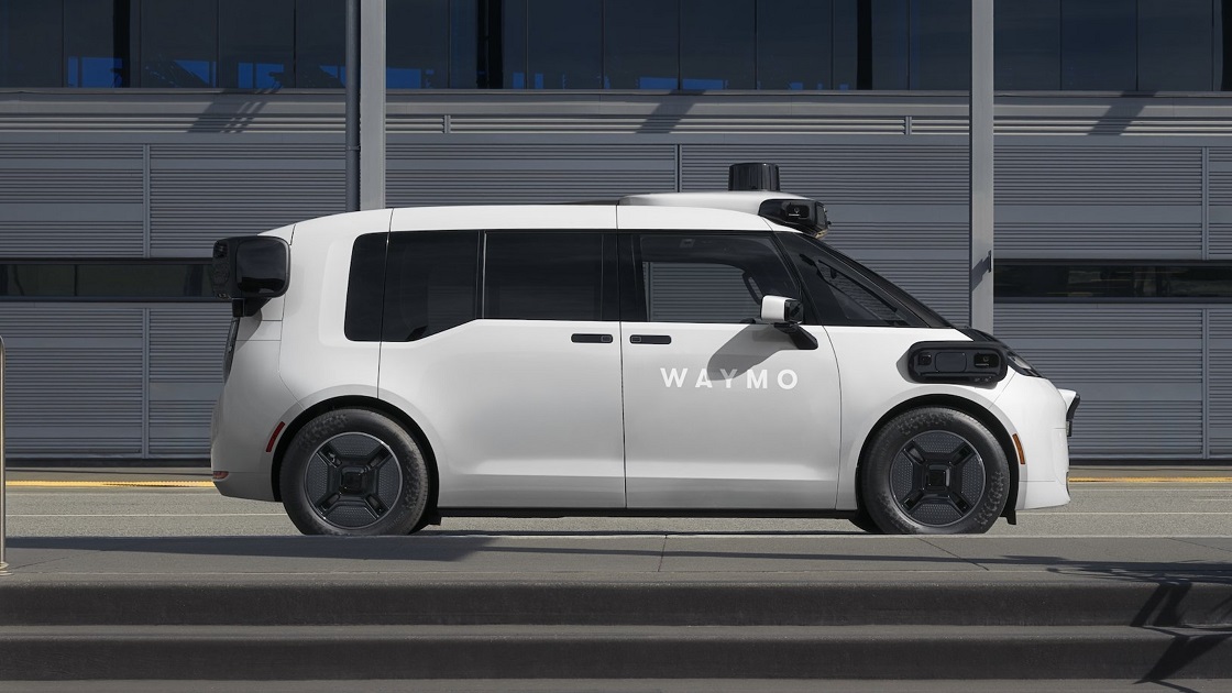 A Waymo silver robotaxi driving autonomously on the road